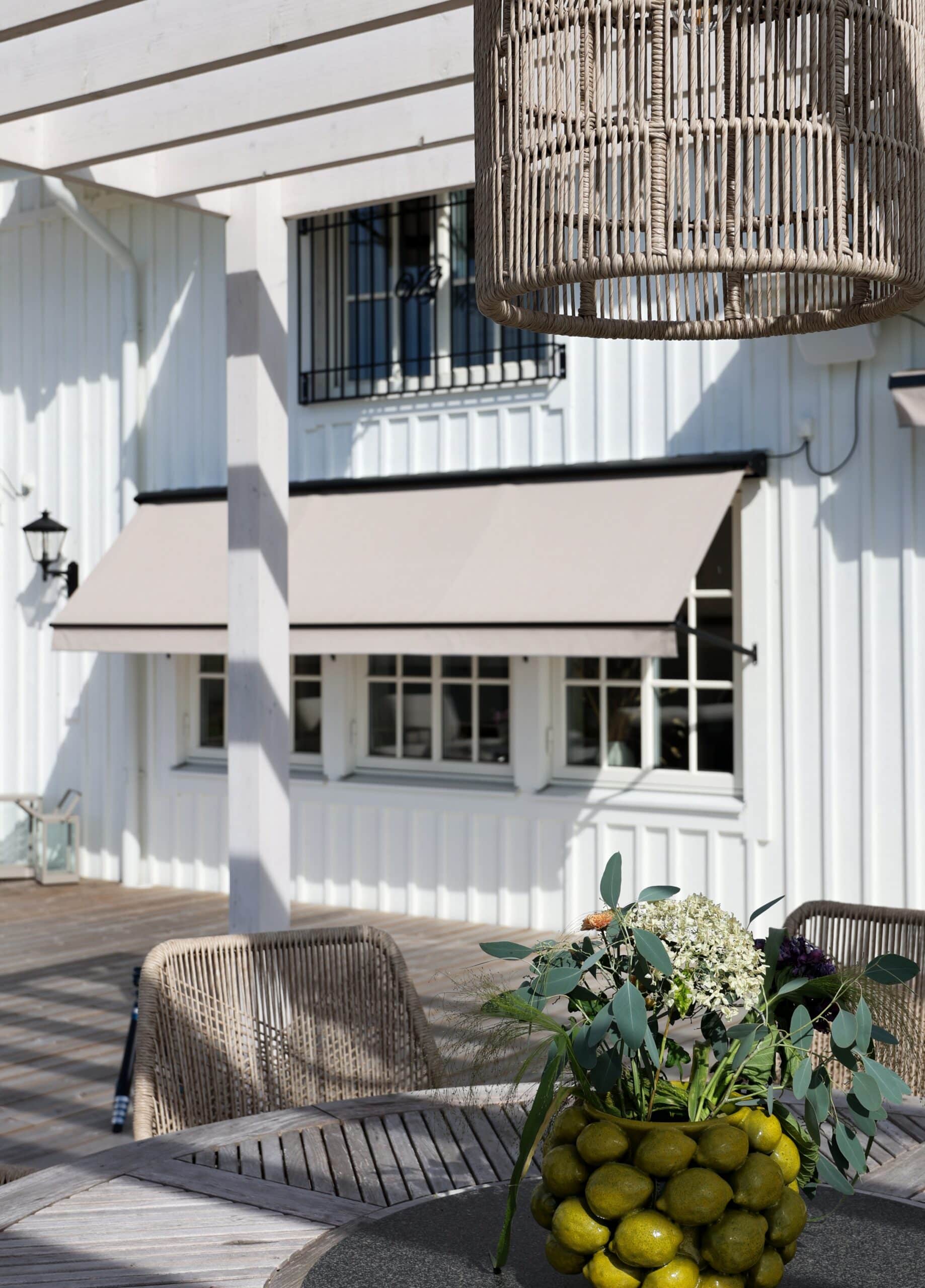 Beige fönstermarkis med svart stång och etikett från Hestra Markis.