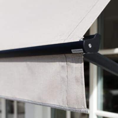 Detaljvy av en fönstermarkis i ljusgrått tyg med synliga sömmar och metallarm.