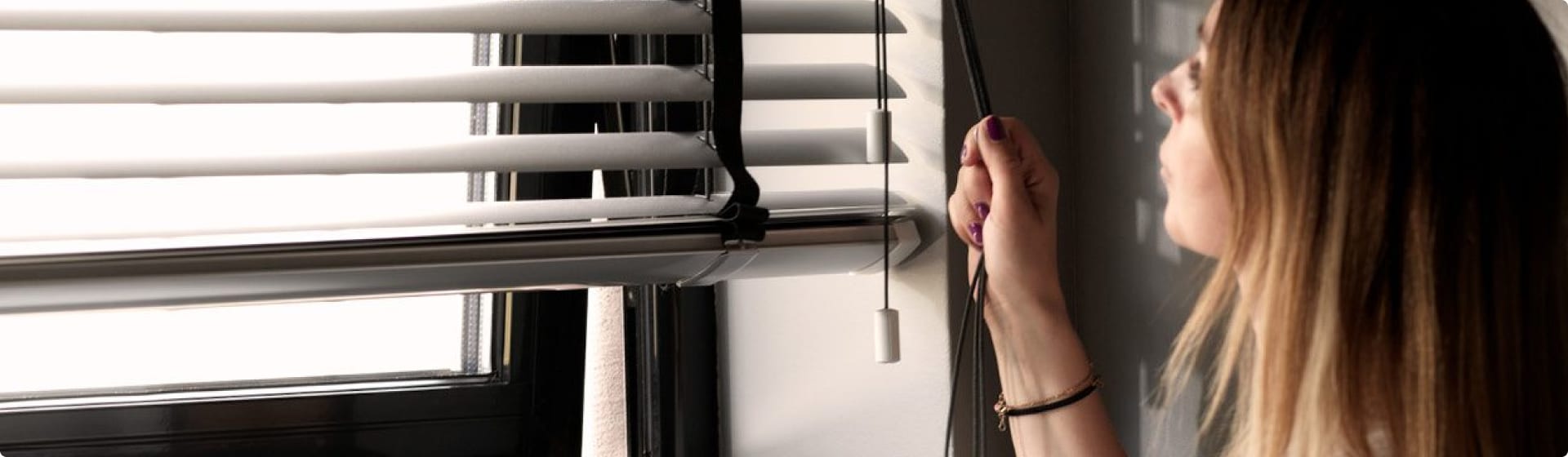 Kvinna sänker sina persienner