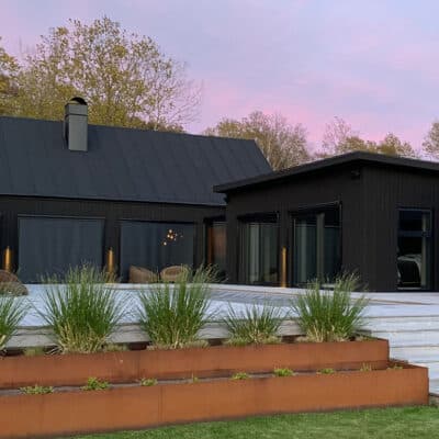 Modern villa med svarta screenmarkiser på glaspartier