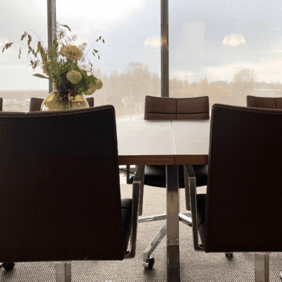 Kontorsfönster med neddragen screenmarkis som dämpar ljusinsläpp.