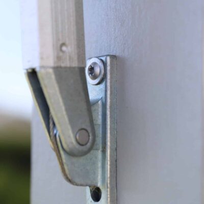 Närbild på metallfäste för markis monterat på trävägg