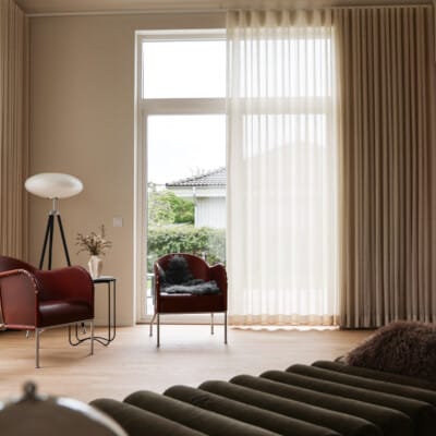 Långa ljusa gardiner i vardagsrum med stora fönster.