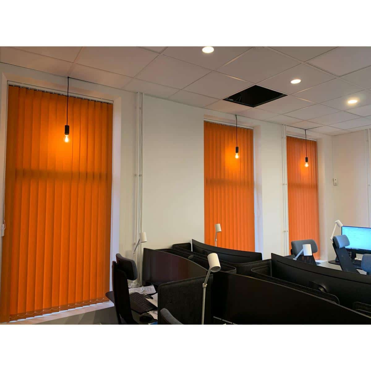 Kontorsmiljö med orange vertikala persienner.
