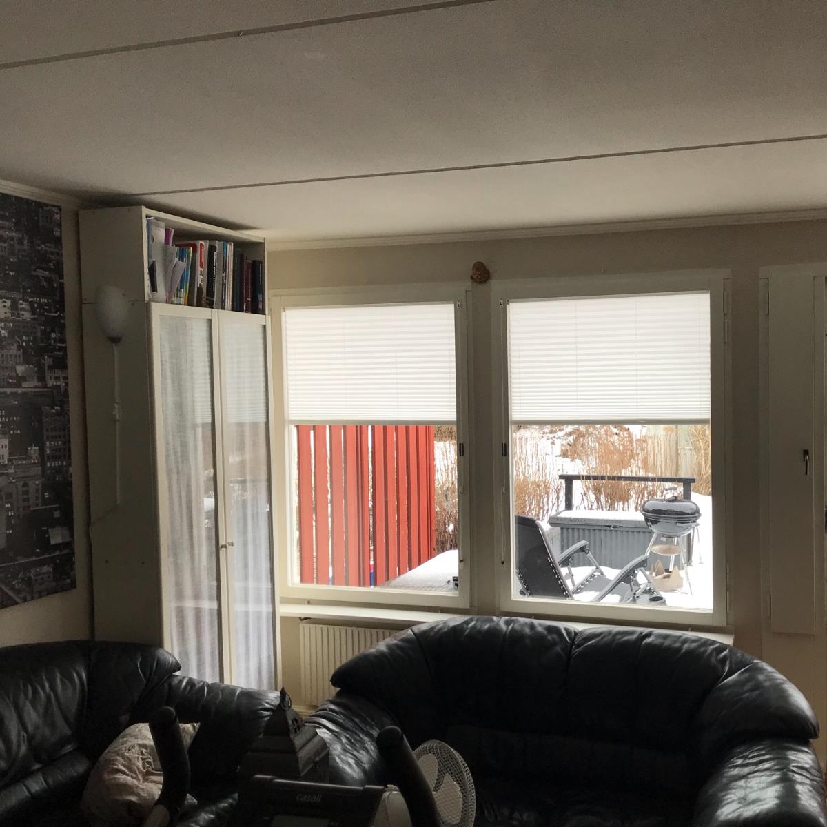 Fönster med vita plisségardiner